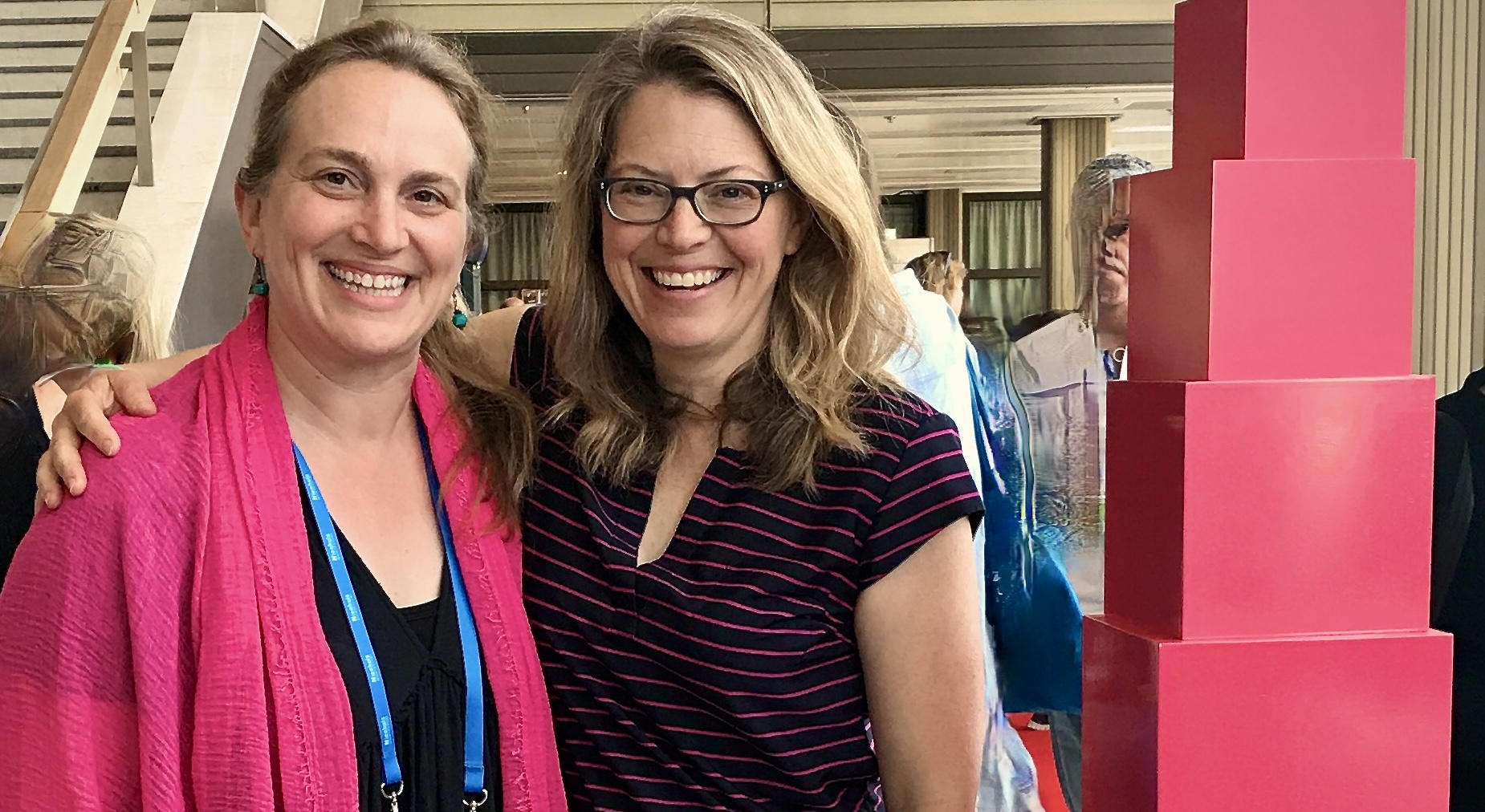 Megan and Kate posing next to a large model of the pink tower.