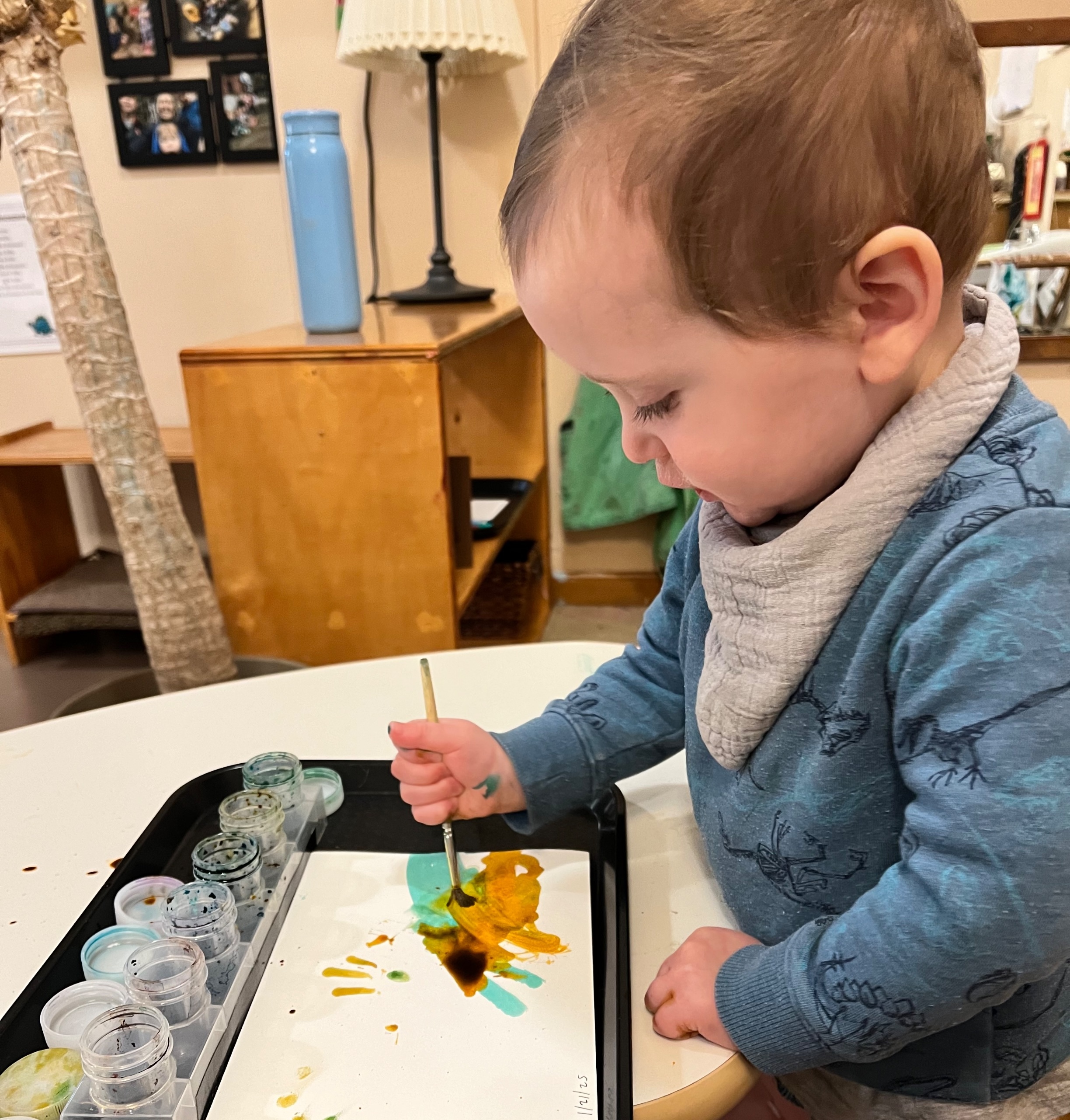 Toddler boy painting with watercolor paints